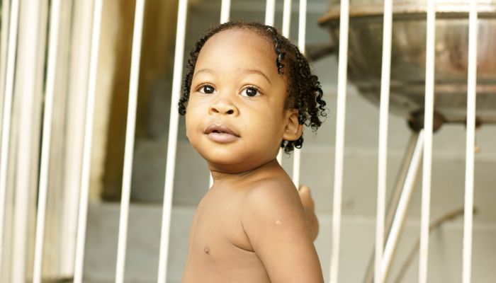 Baby holding onto gate.