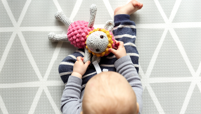 baby sitting on a play mat