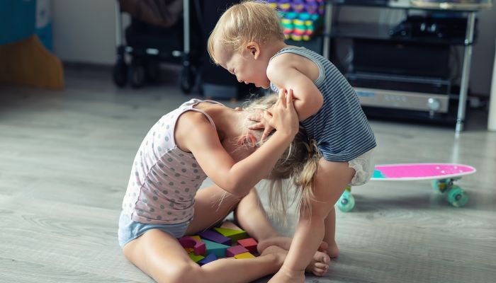 Baby pulling sister's hair.