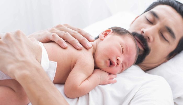 Baby sleeping on dad.