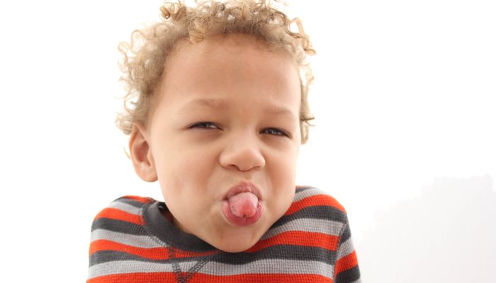 Boy sticking out tongue.
