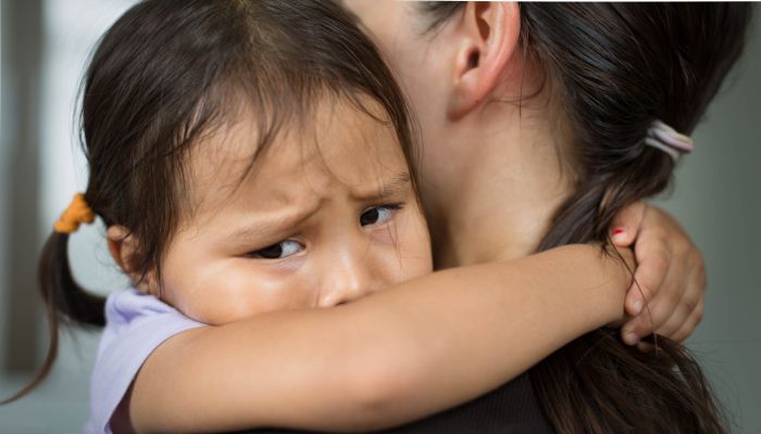 Sad girl hugging mom,