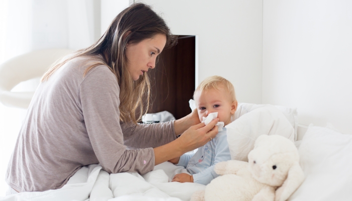 Mother cleaning her baby's nose.