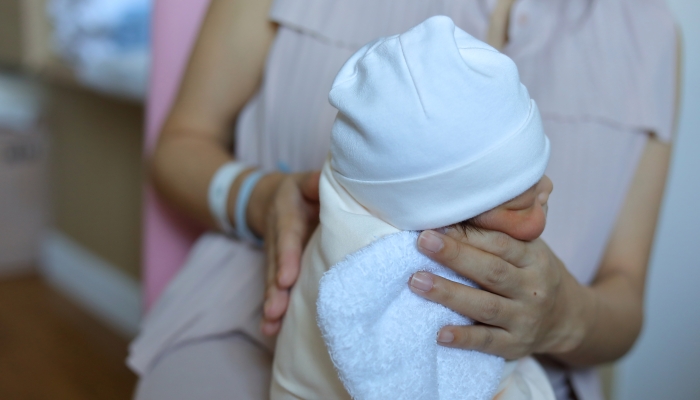 Mother helping her newborn to burp.