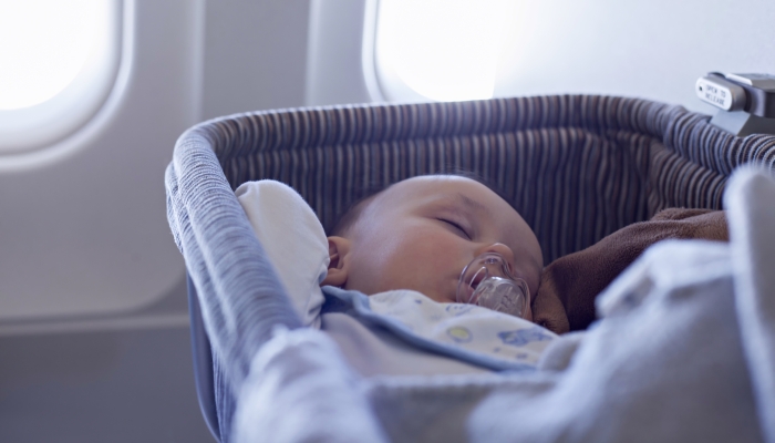 Sleeping baby in a travel crib.