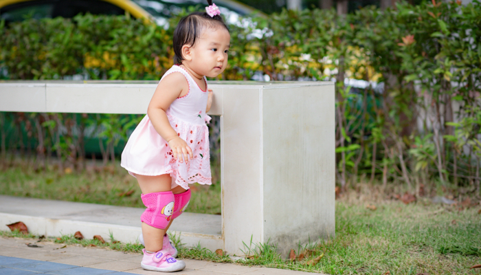 A baby wearing knee pads