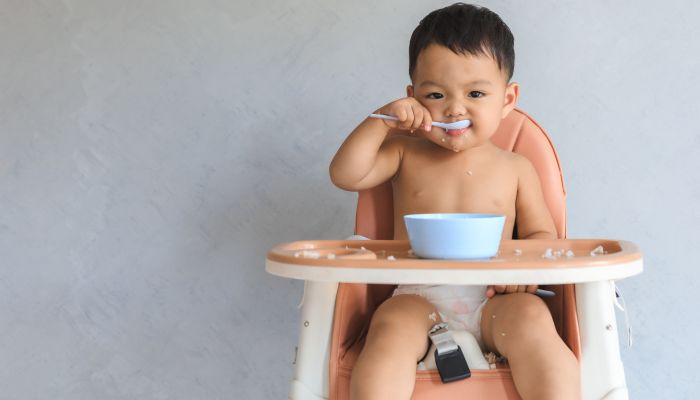 Boy sitting in high chair.