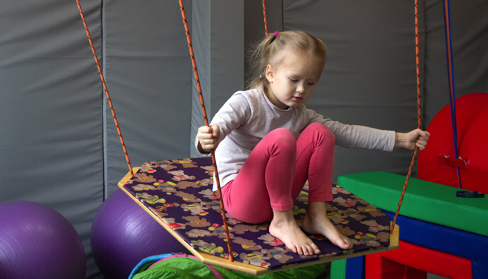 little girl on a platform swing