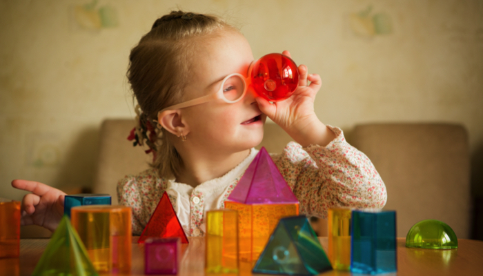 little girl looking through a red block