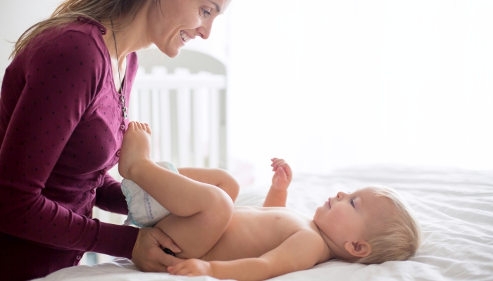 Mom changing baby diaper.