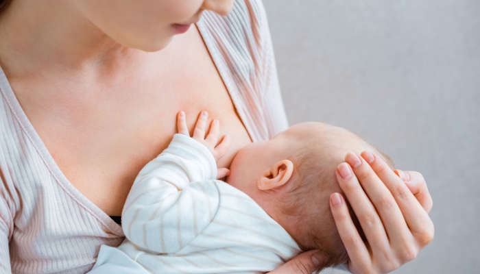 Mother breast feeding daughter.