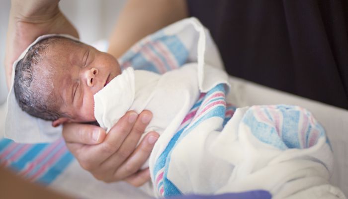 Baby wrapped in a receiving blanket.