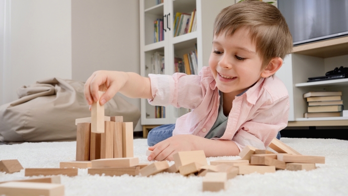 Boy playing with wooden toys.