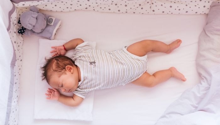 Newborn baby sleeping in a crib.