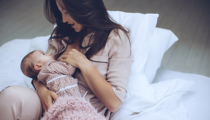 The woman is breastfeeding her baby.