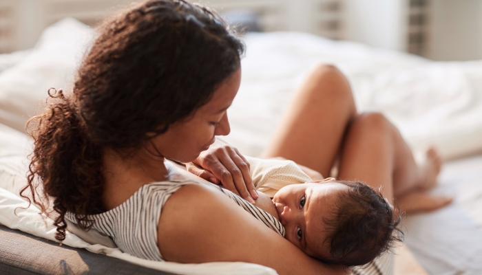 Young African-American mother breastfeeding her son.