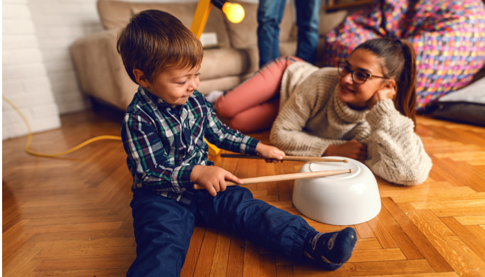 Little boy using a bowl as a drum.