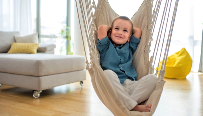 A boy in an indoor hammock swing.