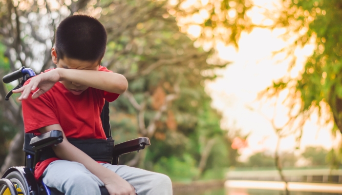 Asian disabled child is sitting on wheelchair.