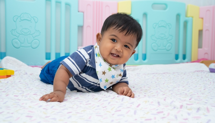 Cute little asian baby lying and crawling on floor