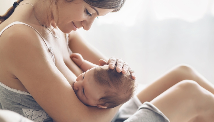 Loving mom breastfeeding her newborn baby.