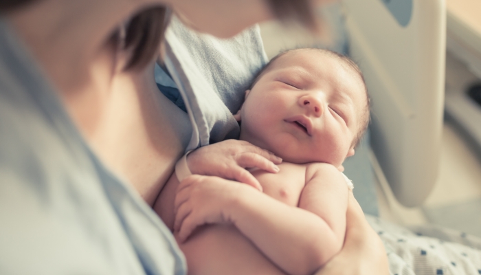 New born baby boy resting in mothers arms