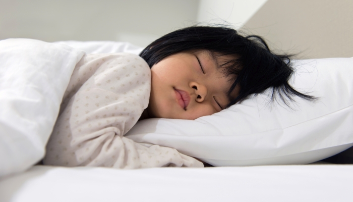 Sweet toddler child sleeping in bed.