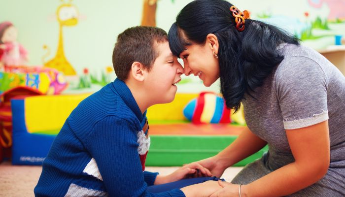 Special needs boy holding hands with mom.