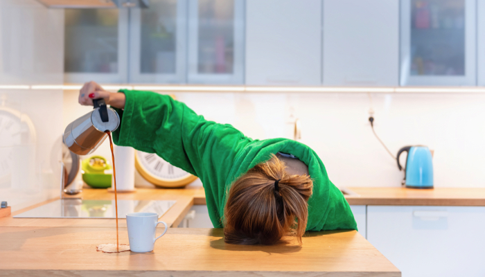 A tired mom pouring herself coffee and missing her cup.