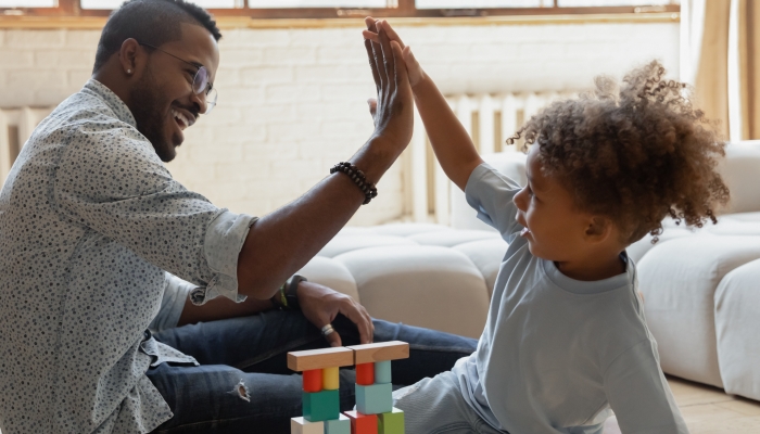 Dad giving high five to toddler son.