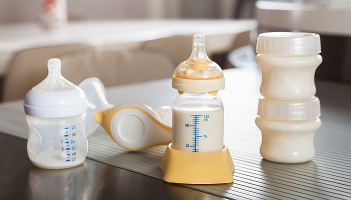 Baby bottle with milk and manual breast pump.