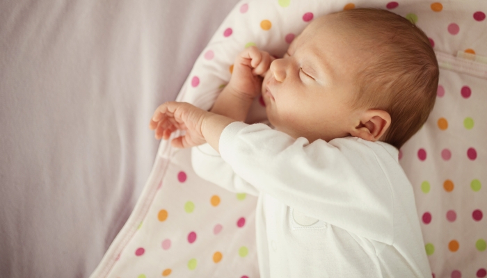 Baby girl sleeping in bed.