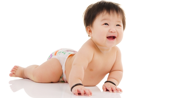 Cheerful asian baby looking up and smile while crawling.