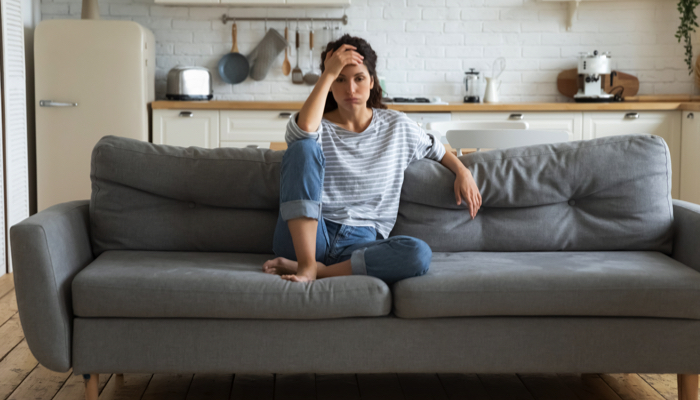 Stressed mom sitting on a couch.