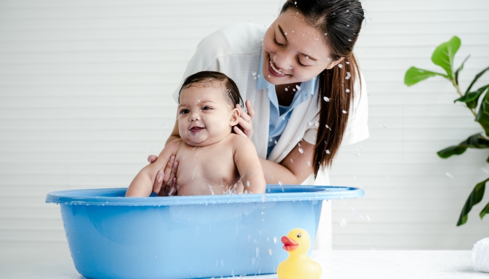 Asian mother Bathing her 7 month old daughter.