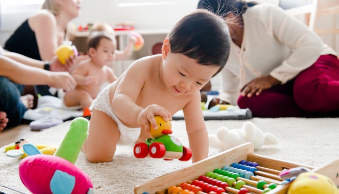 Baby playing with a wooden car.