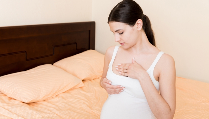 Close Up of pregnant women having painful feelings in breast.