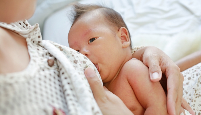 Close up mother breast feeding her newborn child.