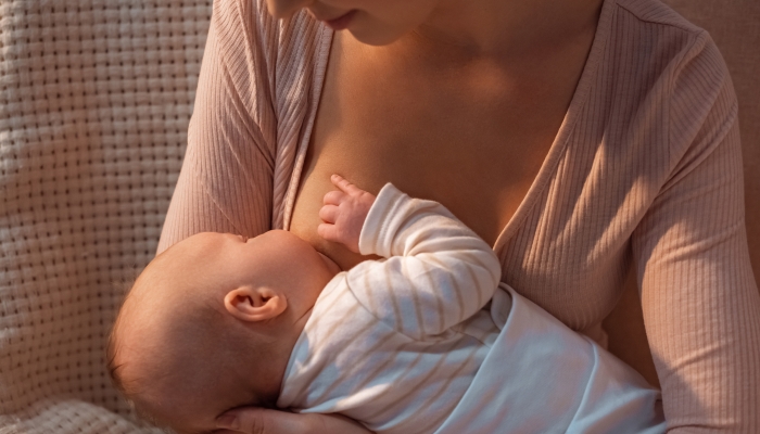 Young mother breastfeeding baby at night.