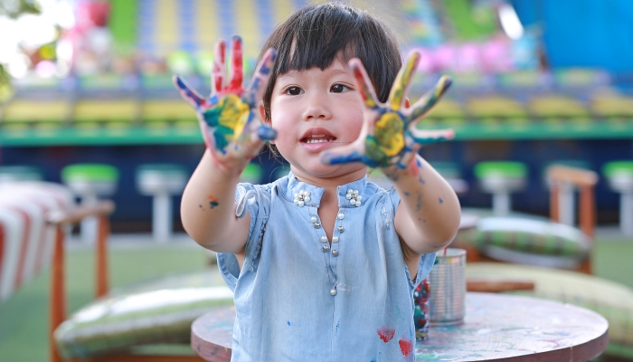 Cute little girl with painted hands.