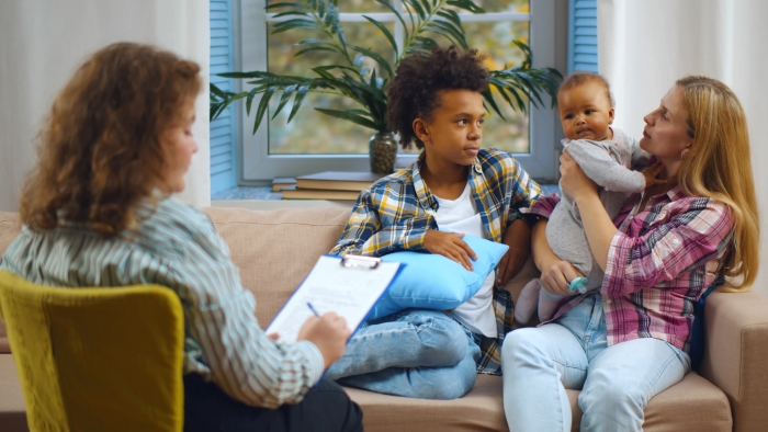 Female case worker visiting woman with adopted children