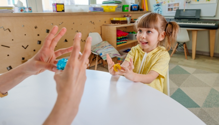 Girl on the lesson of the development of fine motor skills in kindergarten.