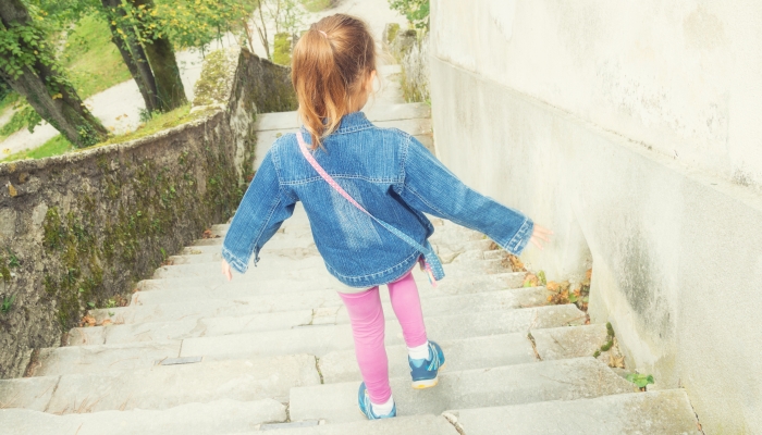 Kid girl going down the stairs alone.