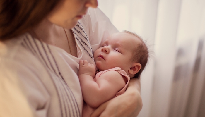 Sleeping newborn in mother's arms.