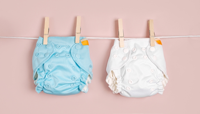 Reusable cloth baby diapers drying on a clothes line.