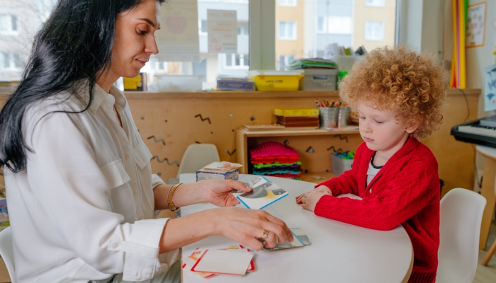 Teacher spreads out puzzle in front of the child.