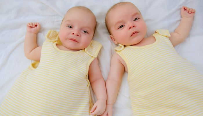 Twin girls in sleep sacks.