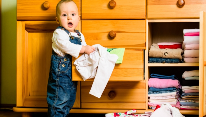 https://www.wonderbaby.org/wp-content/uploads/2022/09/Baby-throws-out-clothes-from-the-storage.jpg