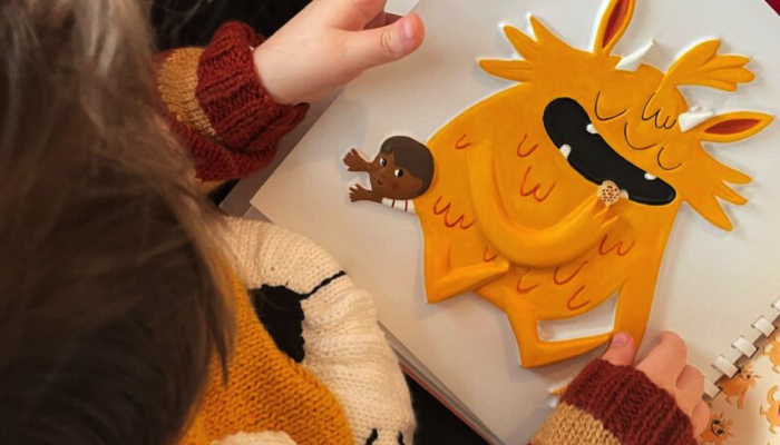 Young child reading a Living Paintings tactile book.