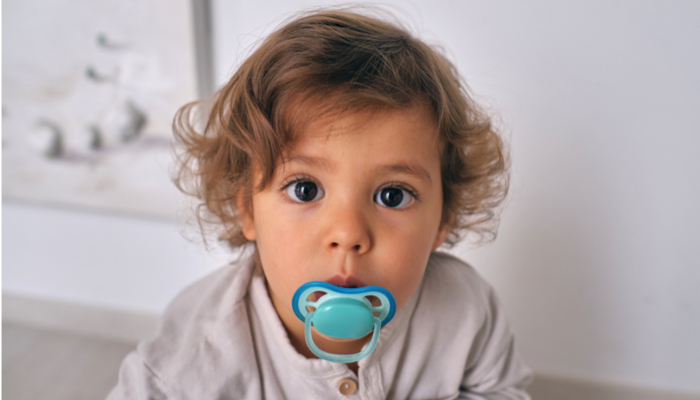 Surprised boy with a pacifier.